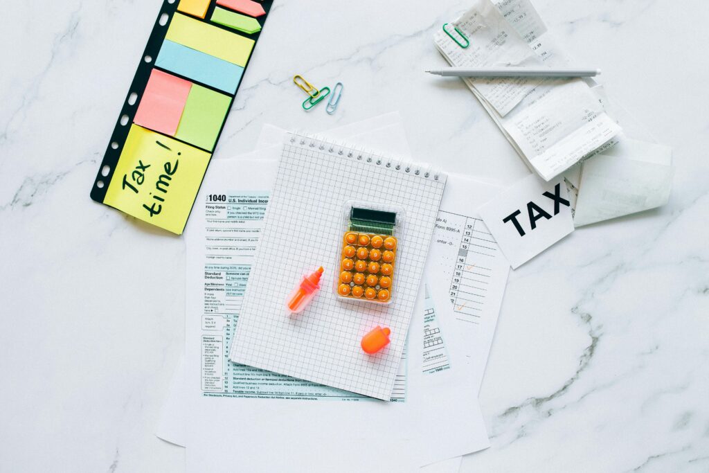 pexels photo 6863333 6863333 Flat lay of tax preparation essentials with calculator, forms, and colorful sticky notes.