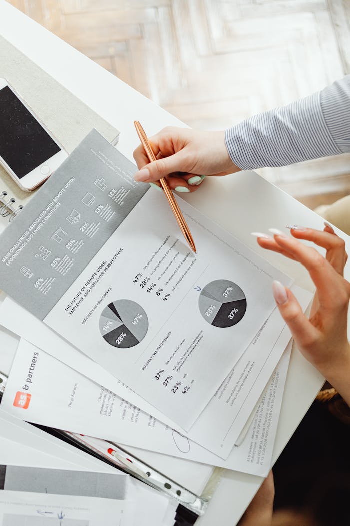 experience-img Close-up of businesswoman analyzing financial reports using pie charts in an office setting.